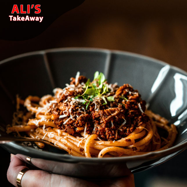 Delicious spaghetti bolognese topped with fresh herbs served at Ali’s Takeaway in Edinburgh.